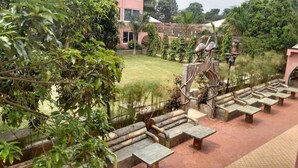 A courtyard with stone benches and a decorative sculpture. - Imperial Golf View Hotel (Entebbe)