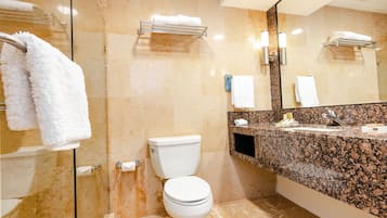 Un baño moderno con inodoro, lavamanos y cabina de ducha de vidrio.
