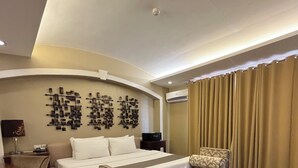 A hotel room with a bed, a sofa, a desk, and a chair. - Hotel Del Rio (Iloilo)