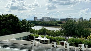A view of a river with buildings and trees in the background. - Hotel Del Rio (Iloilo)