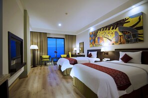 A hotel room with two beds, a TV, a desk, and a large window with a view. - Aston Pontianak Hotel & Convention Center (Pontianak)