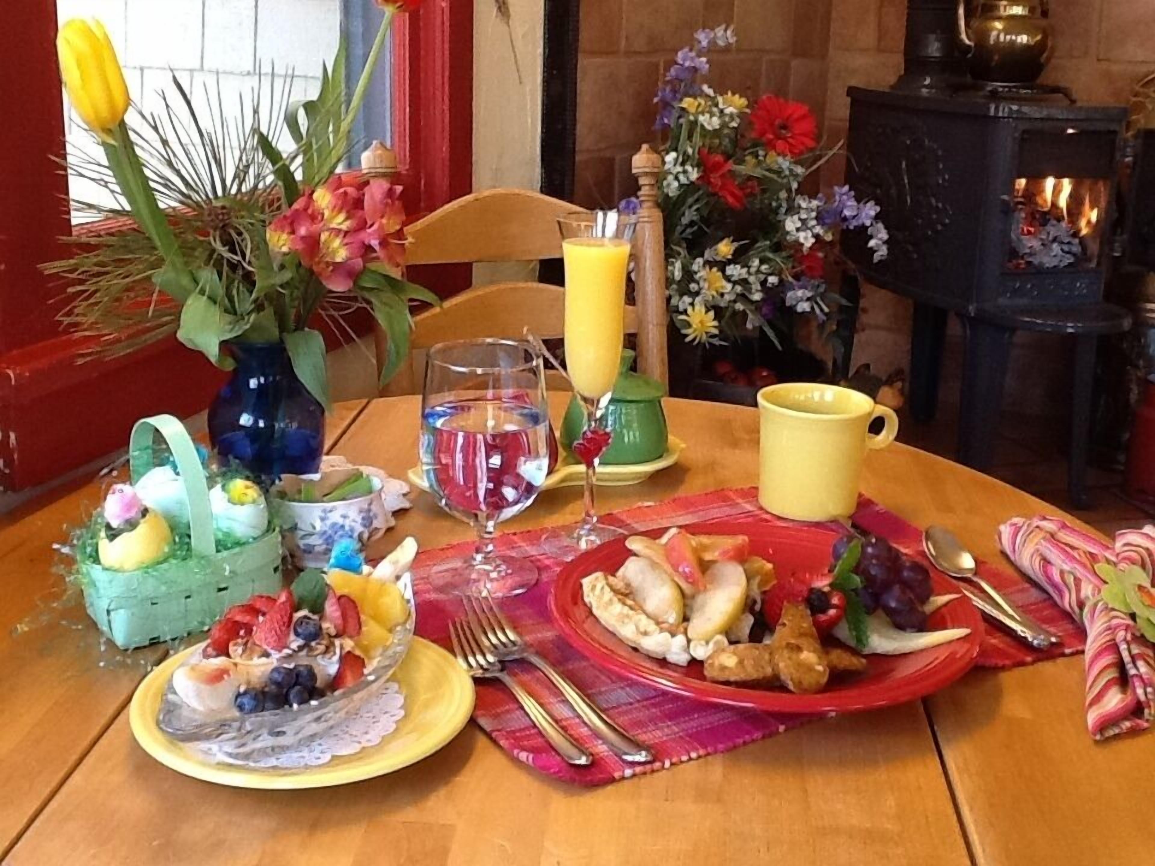 Een ontbijtsetting met een tafel voor twee, compleet met fruit, een glas sap en een kop koffie.