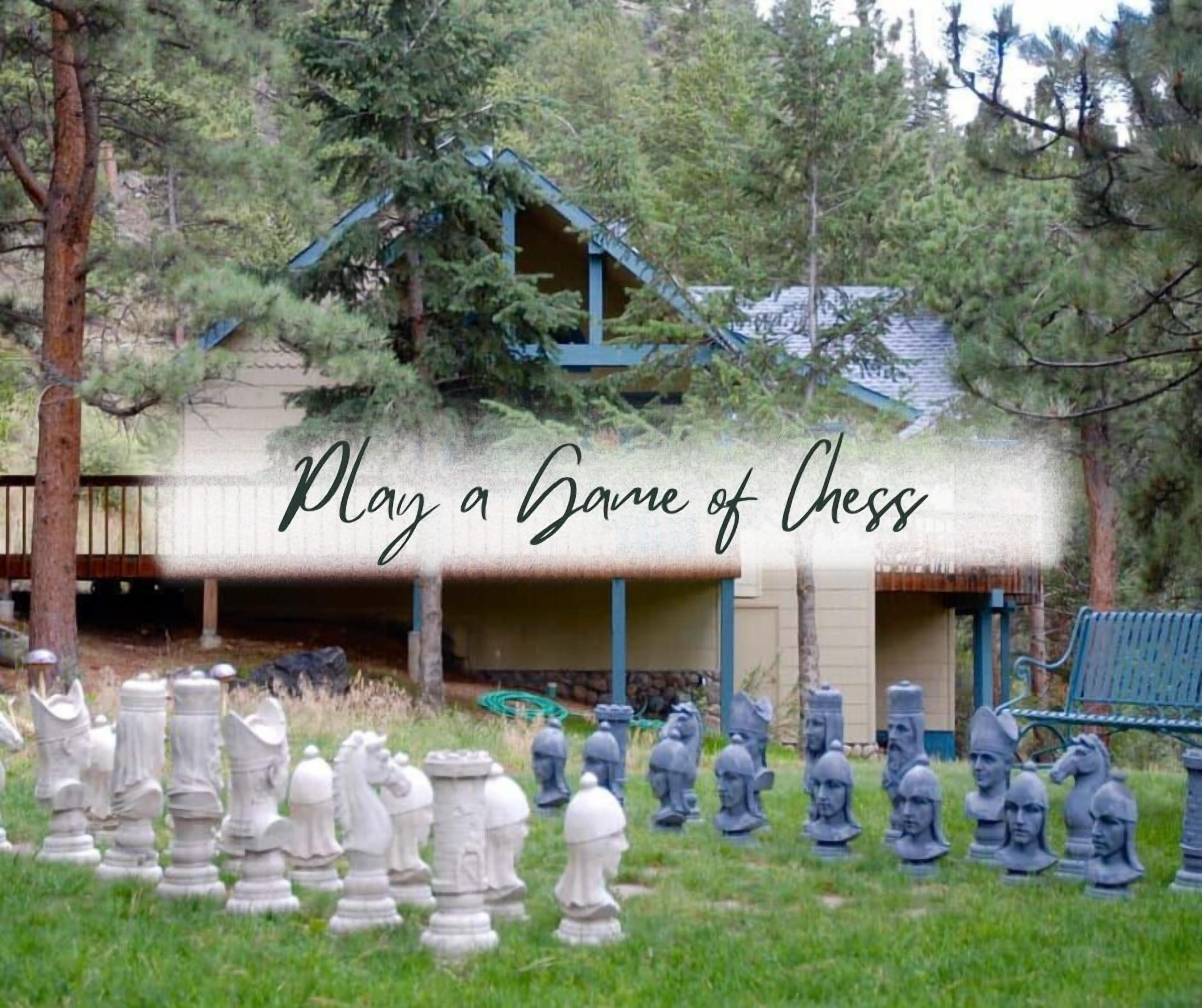 A chessboard with pieces set up in front of a building with a green roof.