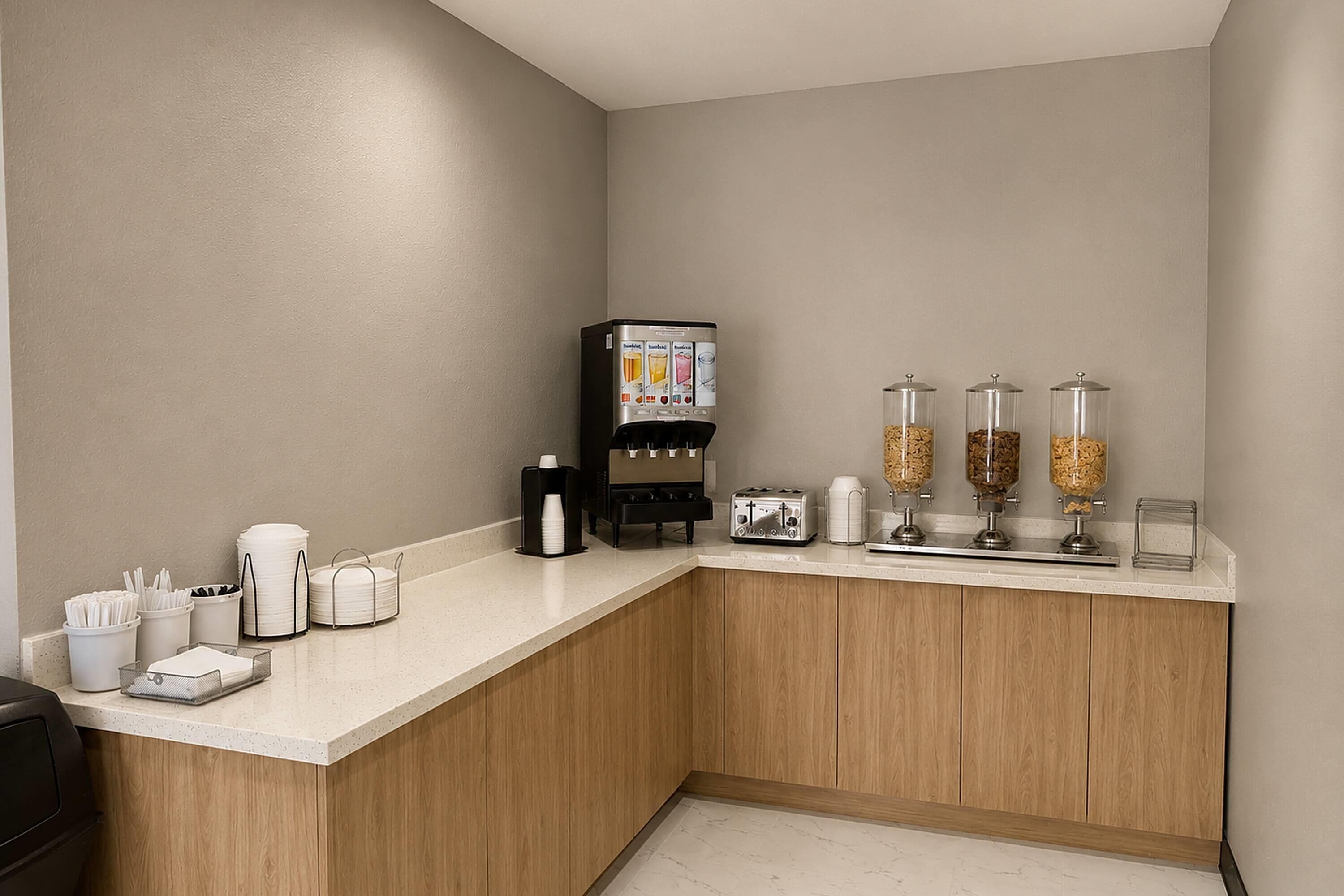 Eine Küchenzeile mit Kaffeemaschine, Toaster sowie Zucker- und Sahnedosierern.