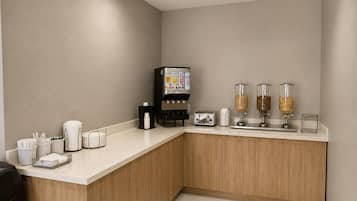 Eine Küchenzeile mit Kaffeemaschine, Toaster sowie Zucker- und Sahnedosierern.