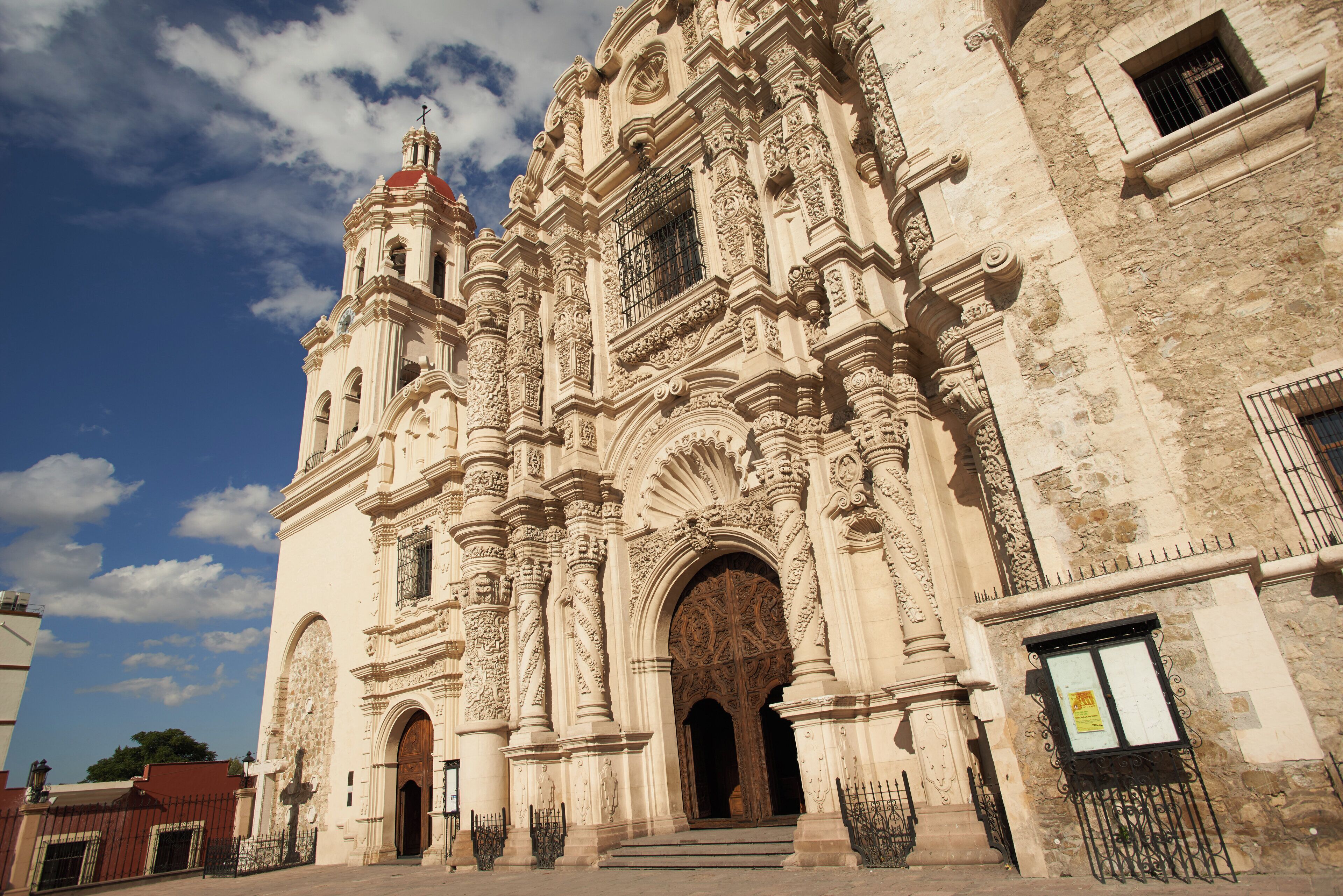 A historic building with ornate architecture, large wooden doors, and a prominent bell tower.