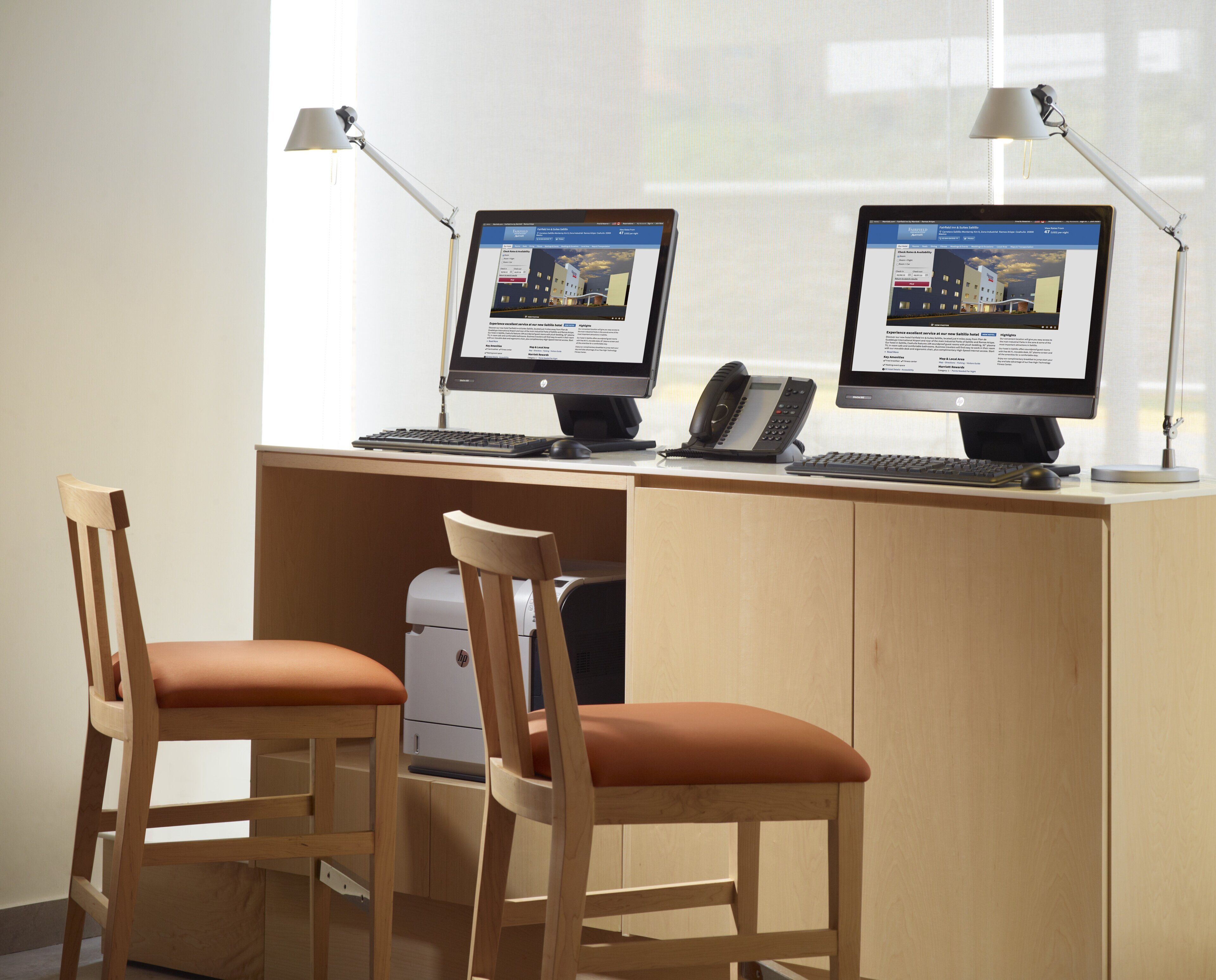A workspace with two HP desktop computers, a telephone, and a printer.