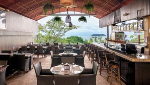 Un espace extérieur aménagé pour les repas, avec des meubles en osier et un comptoir de bar.