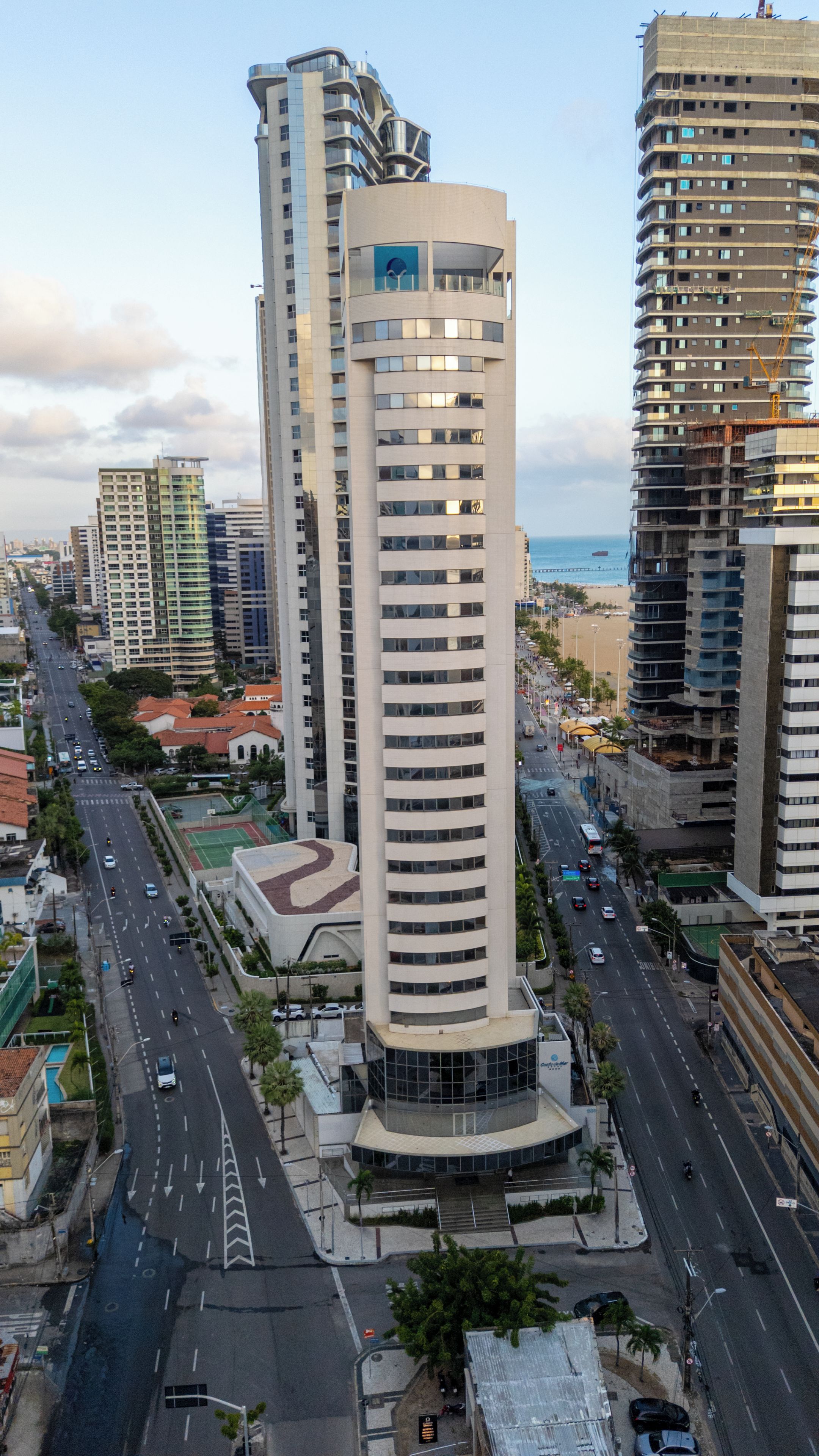 A high-rise building with a modern design, featuring a curved facade and multiple balconies.