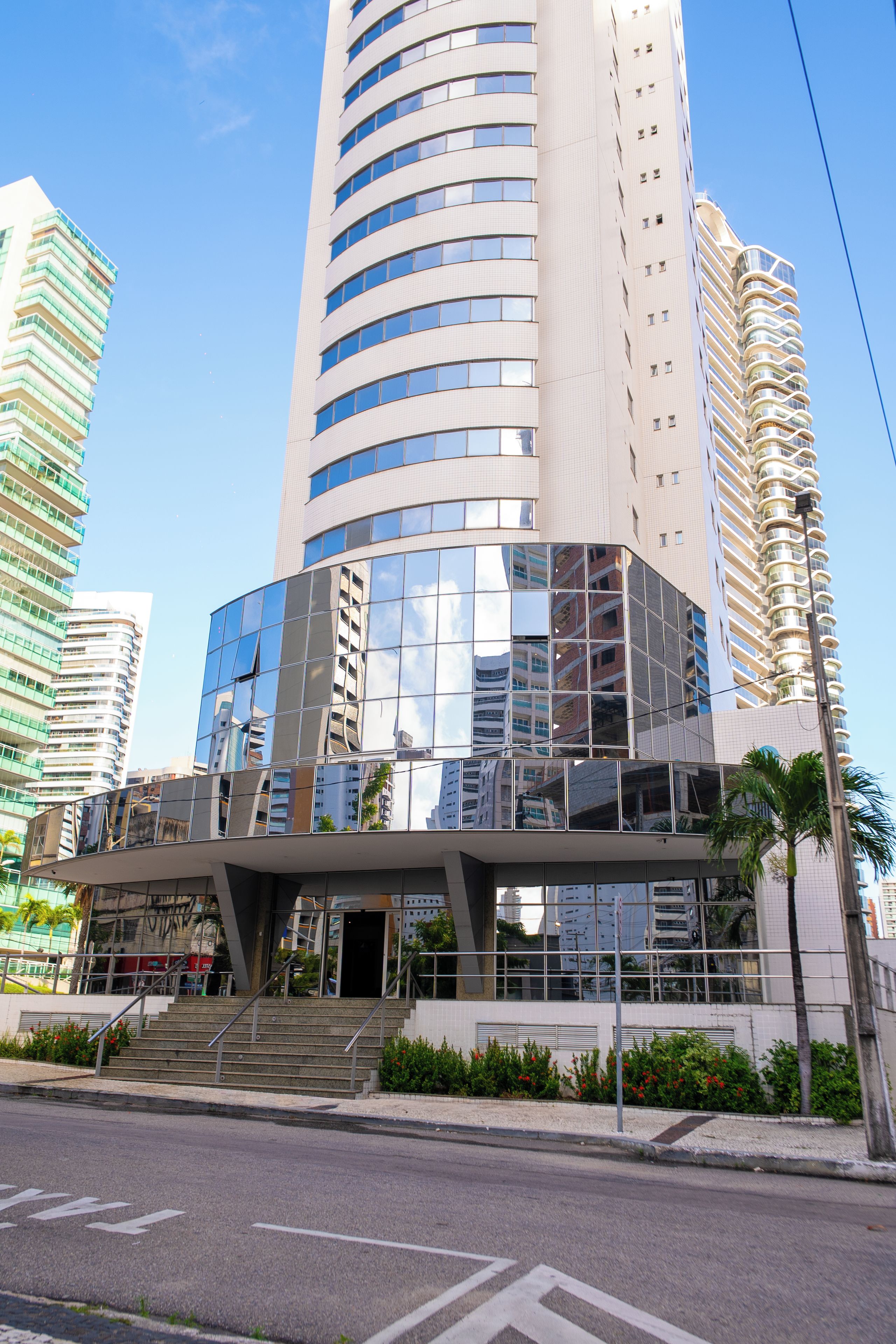 A modern building with a glass facade and a curved entrance.