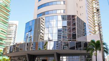 Um edifício moderno com fachada de vidro e entrada curva.
