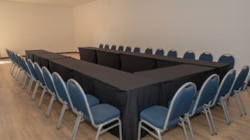 Un salón de conferencias con una mesa larga y sillas.