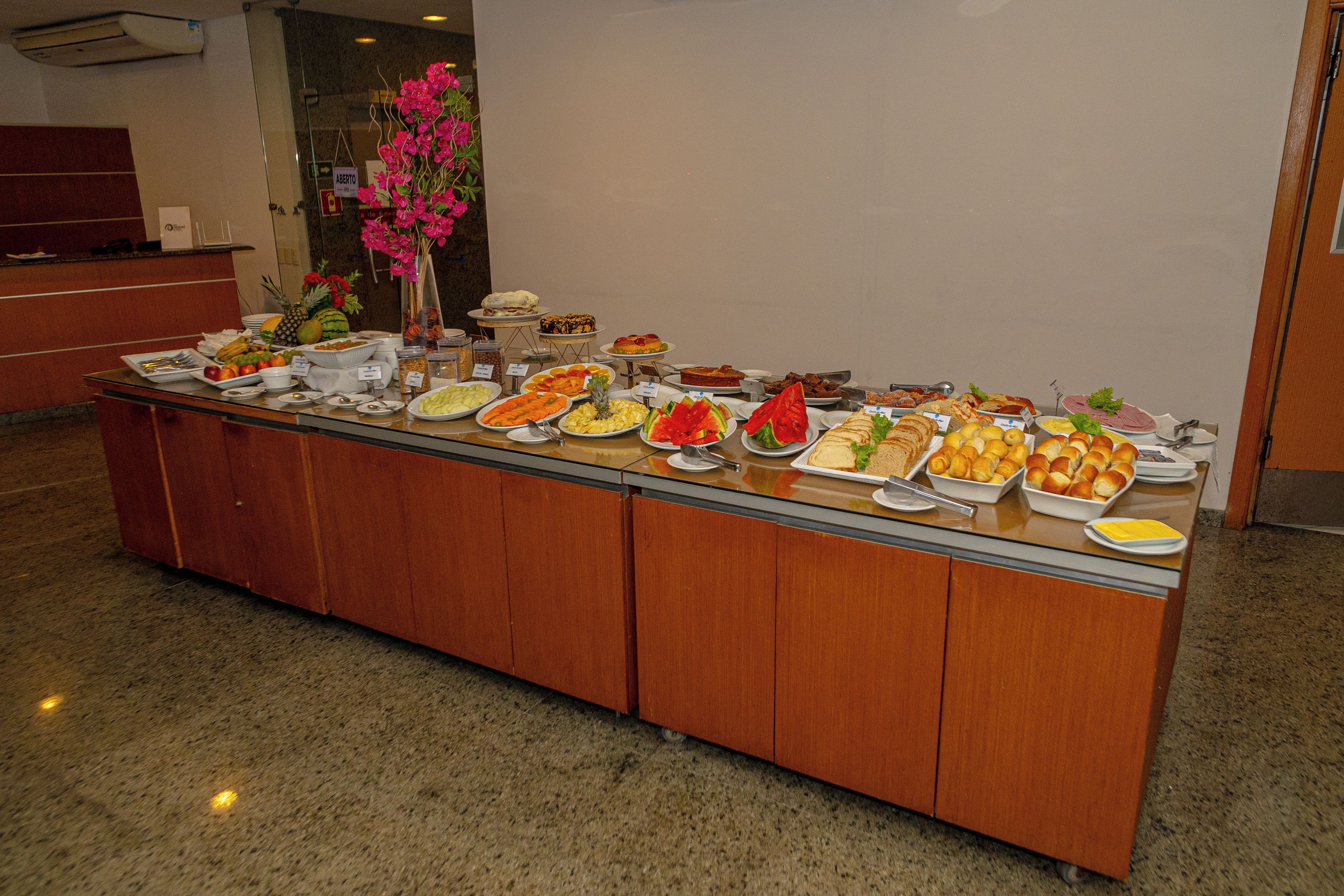 A buffet spread with various food items and a floral centerpiece.