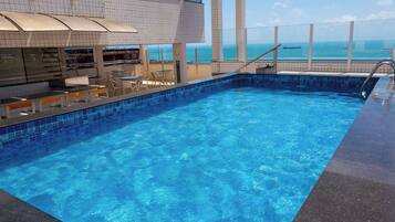 A swimming pool with a bar area and outdoor seating.