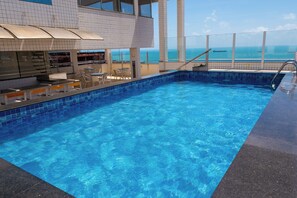 A swimming pool with a bar area and outdoor seating. - Costa Do Mar Hotel (Fortaleza)