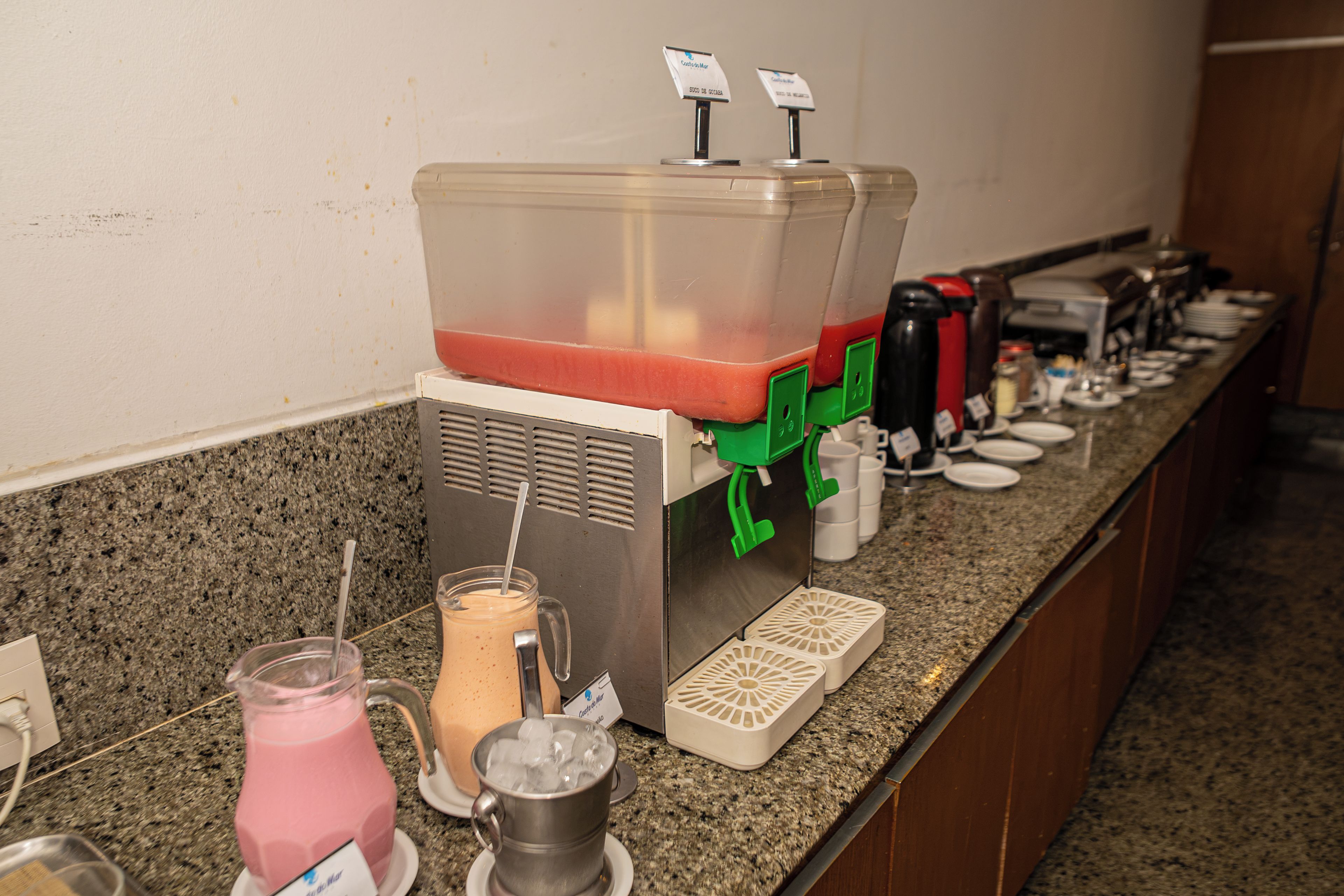 A self-serve beverage station with multiple drink dispensers and a coffee machine.