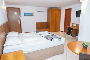A hotel room with a bed, a desk, a wardrobe, and a small kitchenette. - Costa Do Mar Hotel (Fortaleza)