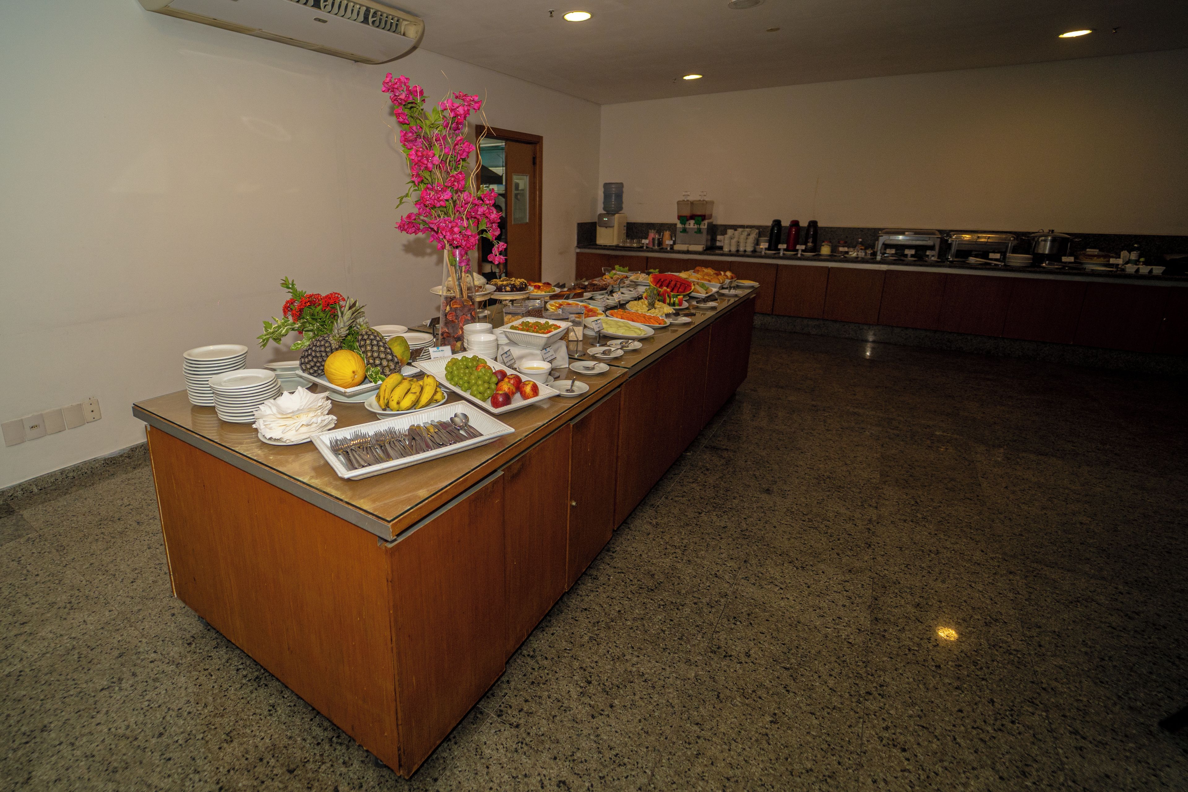 A buffet setup with various food items and a vase of flowers.