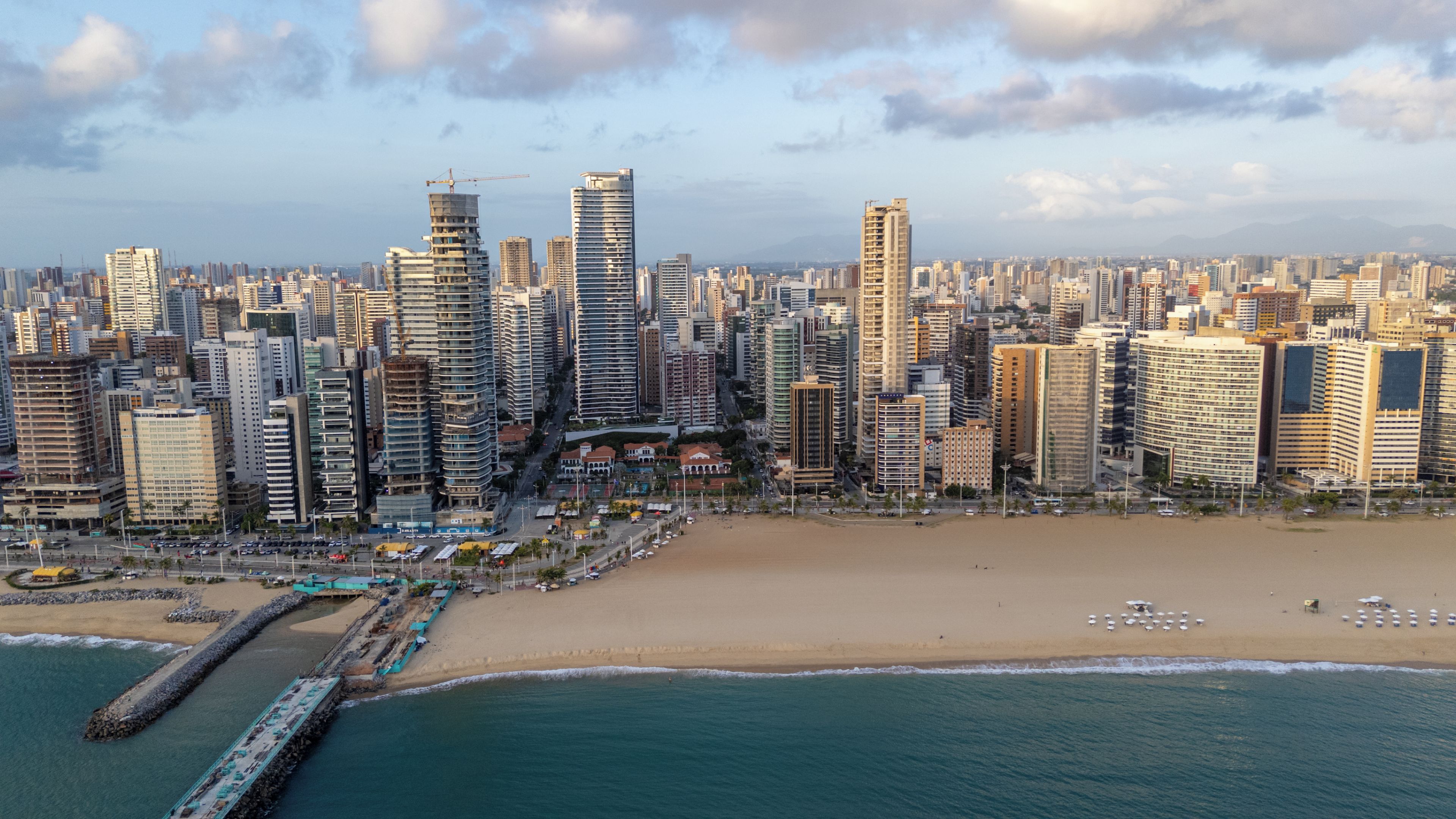 Un paysage urbain côtier avec de hauts immeubles, une plage et une jetée.
