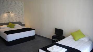 A hotel room with two beds, a desk, and a chair.