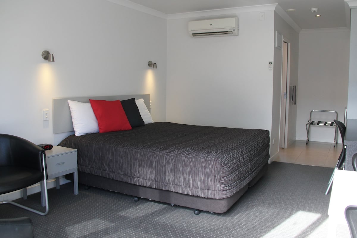 Minibar, escritorio, cortinas blackout y tabla de planchar con plancha 