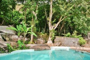 Una piscina al aire libre, sombrillas, tumbonas