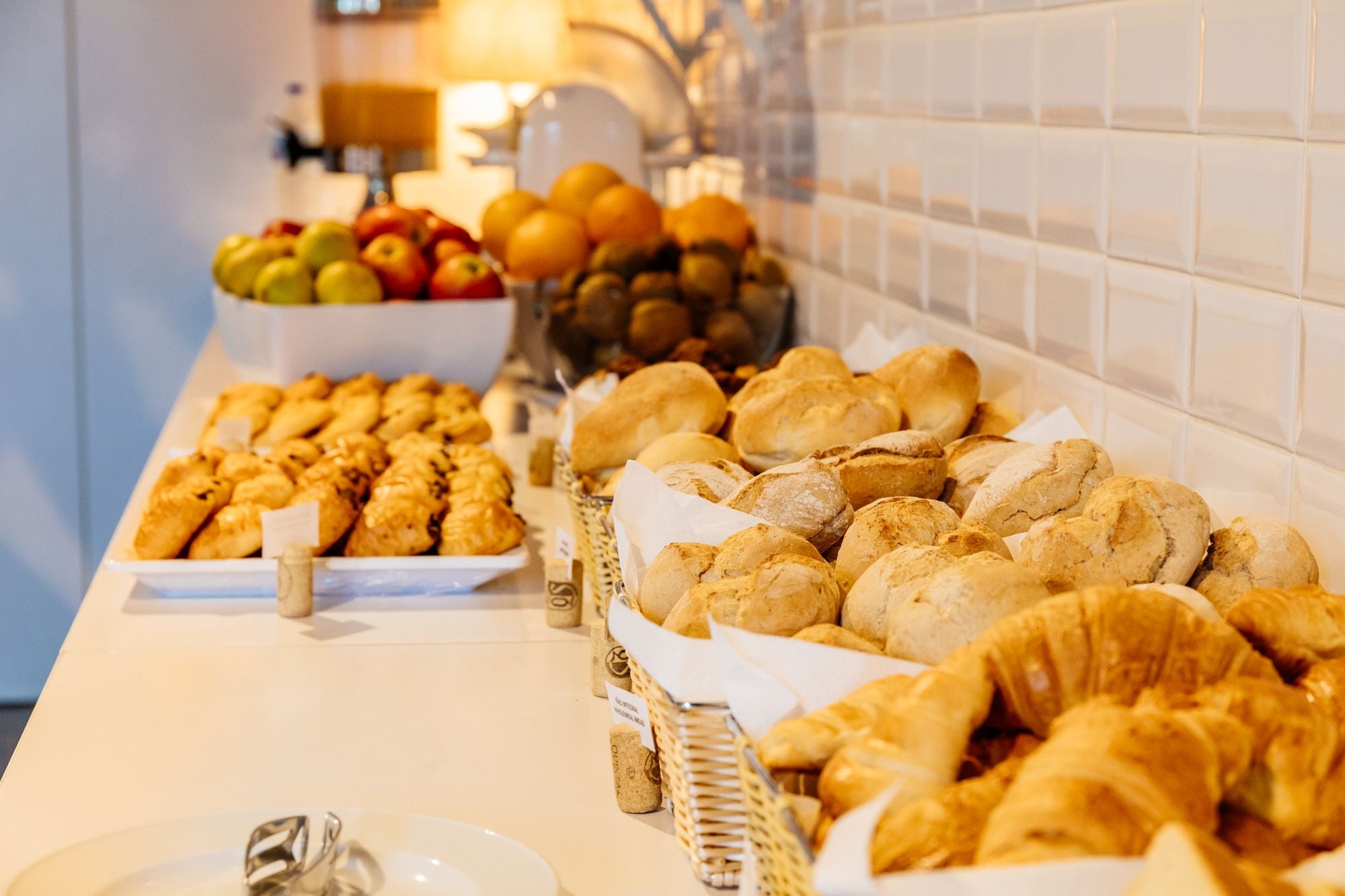 Un buffet proposant une variété de produits de boulangerie et de fruits frais.