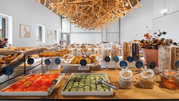 Buffet amb diversos plats, estructura de sostre de fusta i un disseny interior modern.