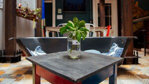 Una pequeña mesa con una planta en un tarro de cristal.