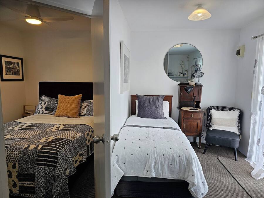Dos habitaciones con camas, una cómoda, una silla y un espejo.