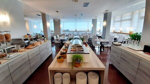 Un comedor moderno con barra libre, varias mesas y vistas al exterior.