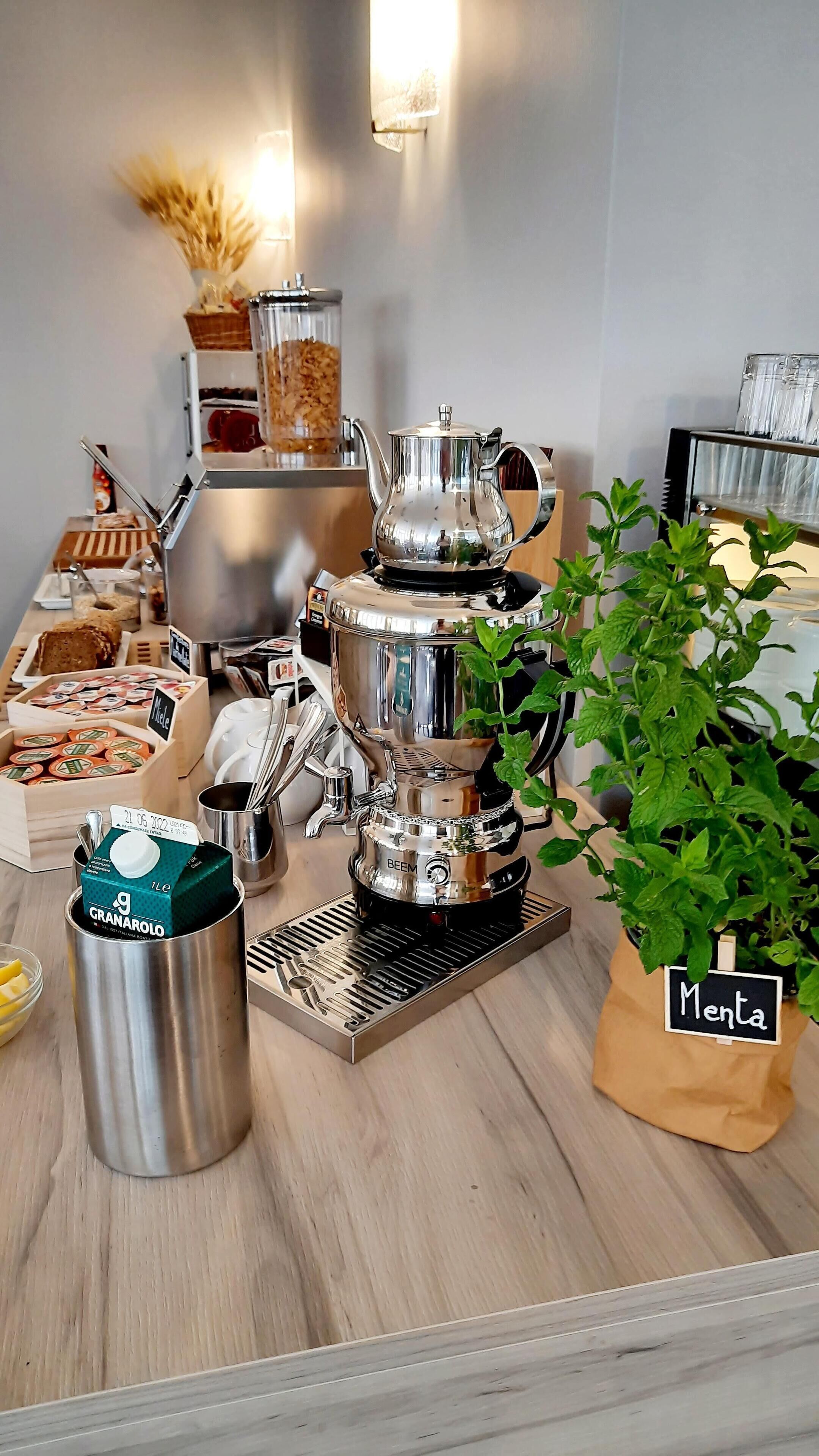 En kaffestation med kaffemaskine, kværn og forskellige kaffekapsler.
