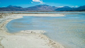 A salt flat landscape with mountains in the background. - Noi Casa Atacama (San Pedro de Atacama)