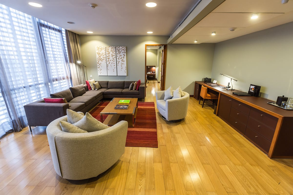 Un salon moderne comprenant un canapé, des fauteuils, une table basse et un bureau avec un ordinateur.