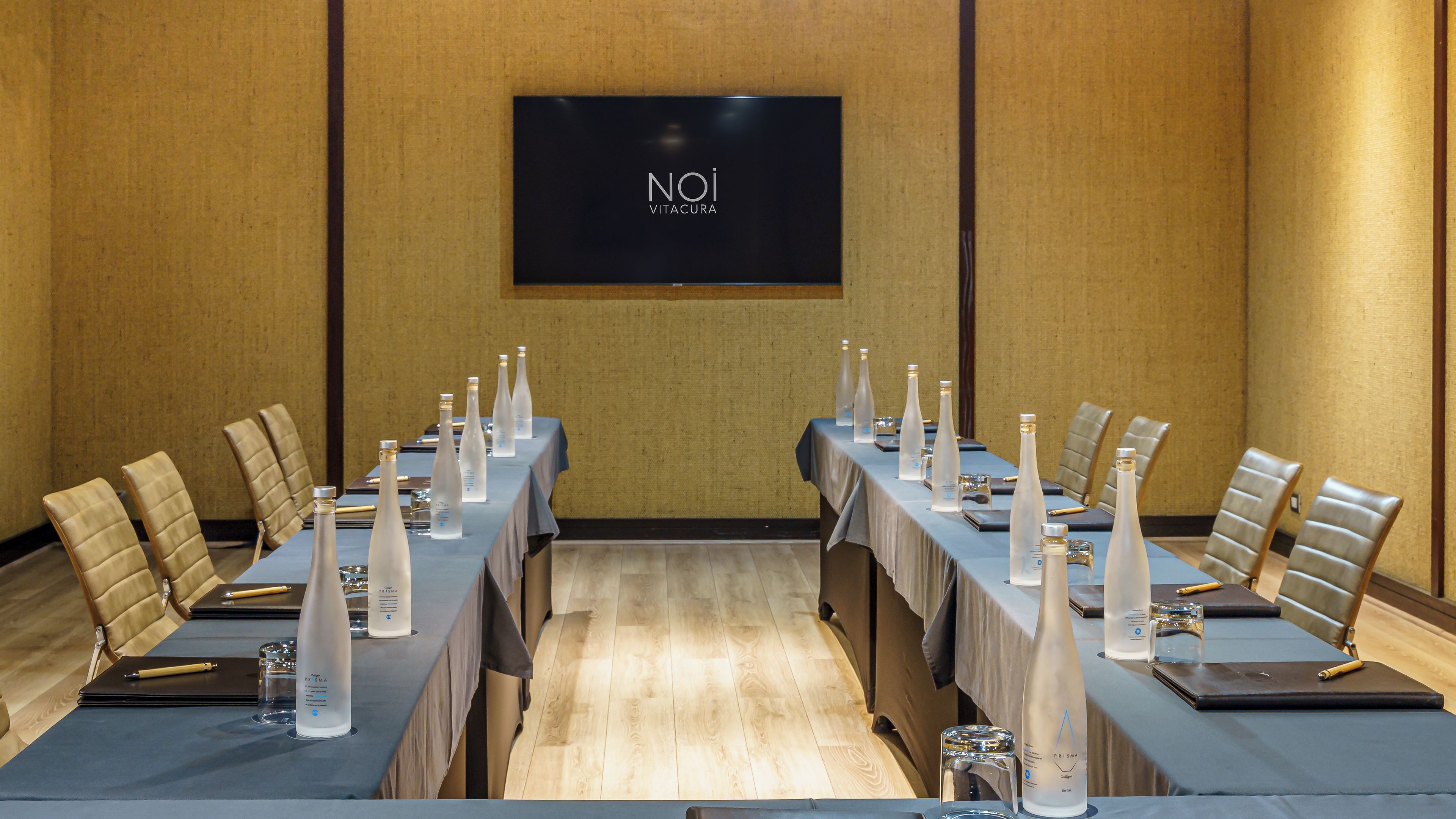 A conference room with a long table, chairs, and water bottles.