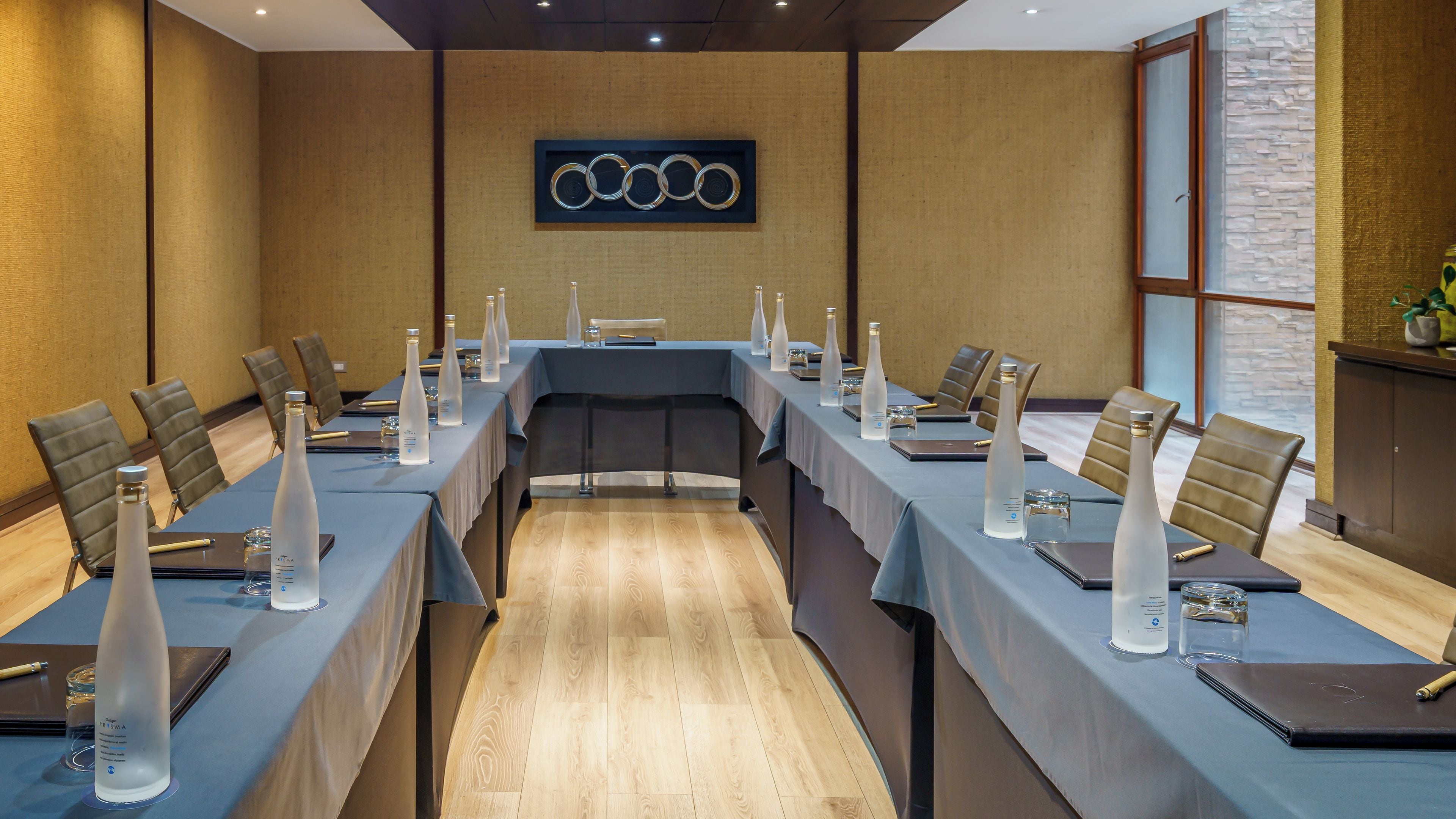 A conference room with a long table, chairs, and water bottles.