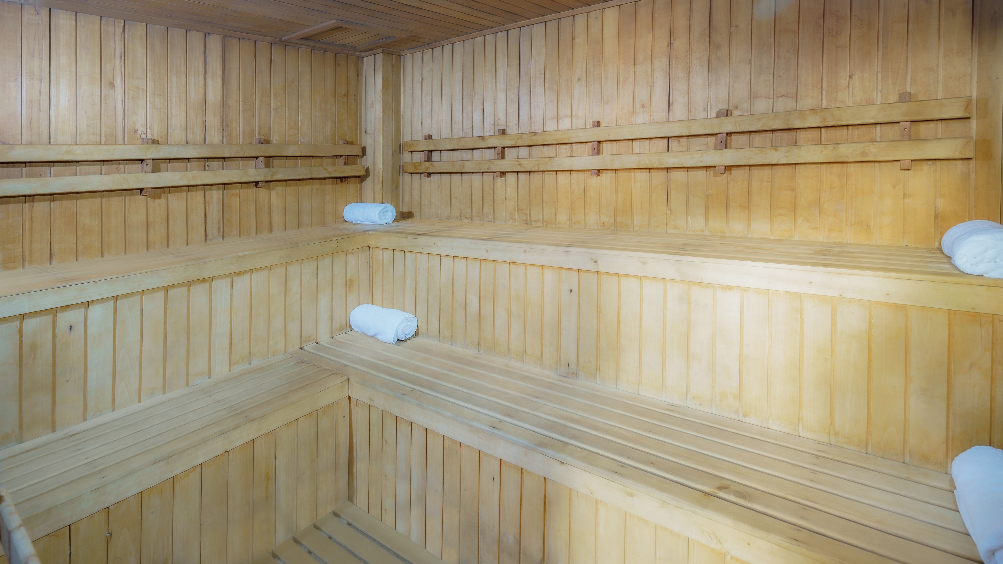 Una sauna con varias bancas y toallas.