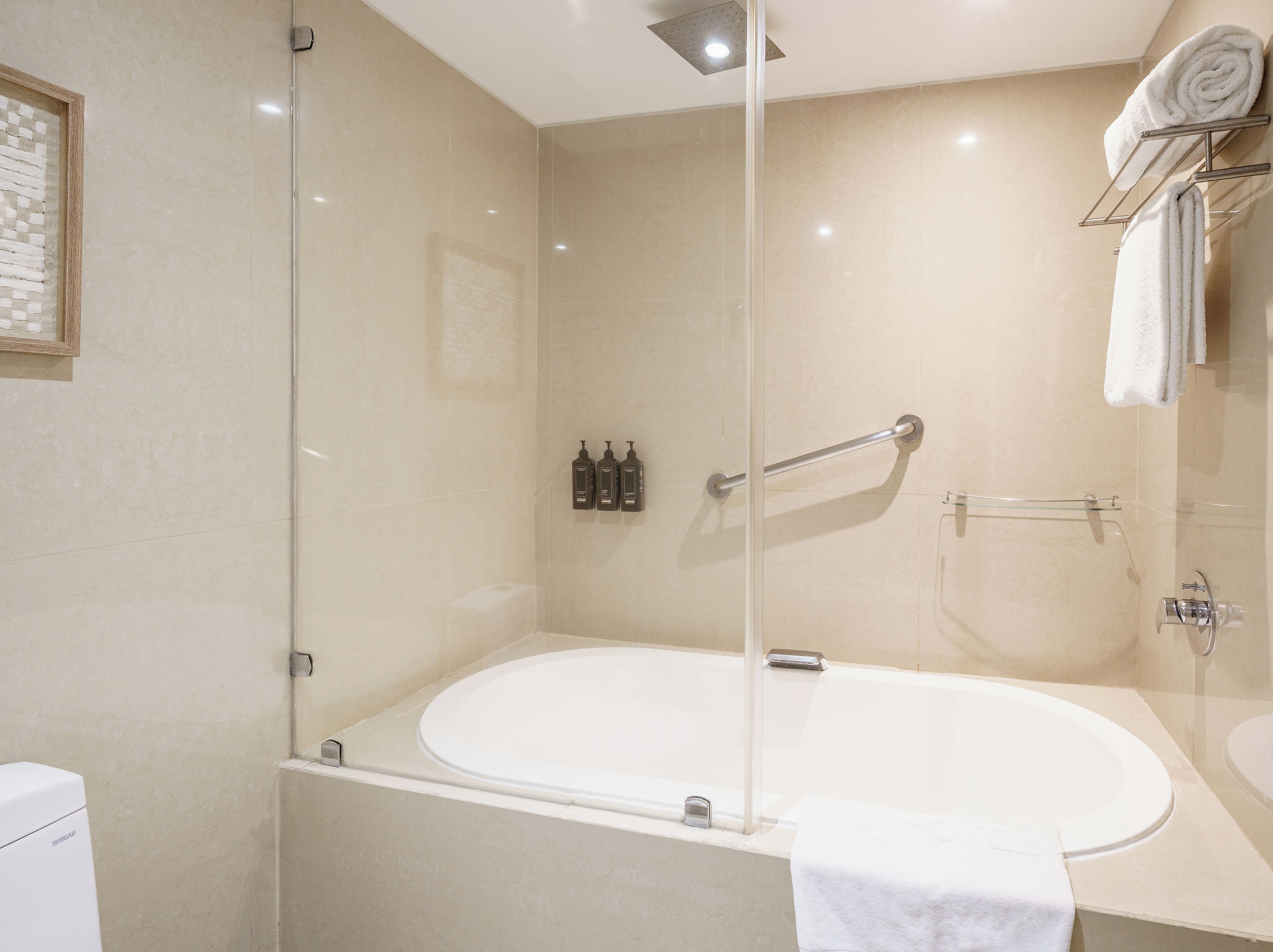 A modern bathroom with a glass-enclosed shower, a freestanding bathtub, and a wall-mounted towel rack.