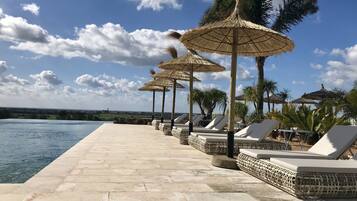 Een binnenzwembad, een buitenzwembad, ligstoelen bij het zwembad