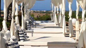 A covered outdoor seating area with white drapes and a view of the landscape. - Hotel Rural Es Turó (Ses Salines)
