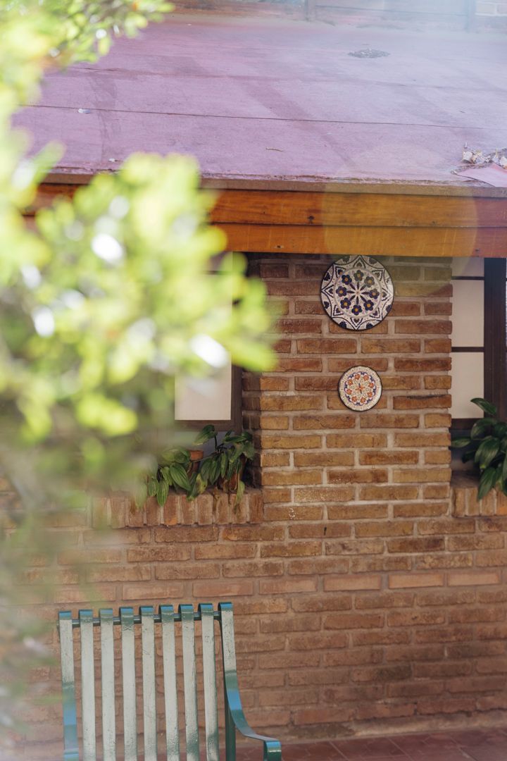 A brick wall with two decorative plates and a bench.