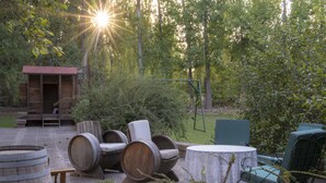 A rustic outdoor seating area with wooden barrels, a table, and chairs. - Lujan de Cuyo B&B (Luján de Cuyo)