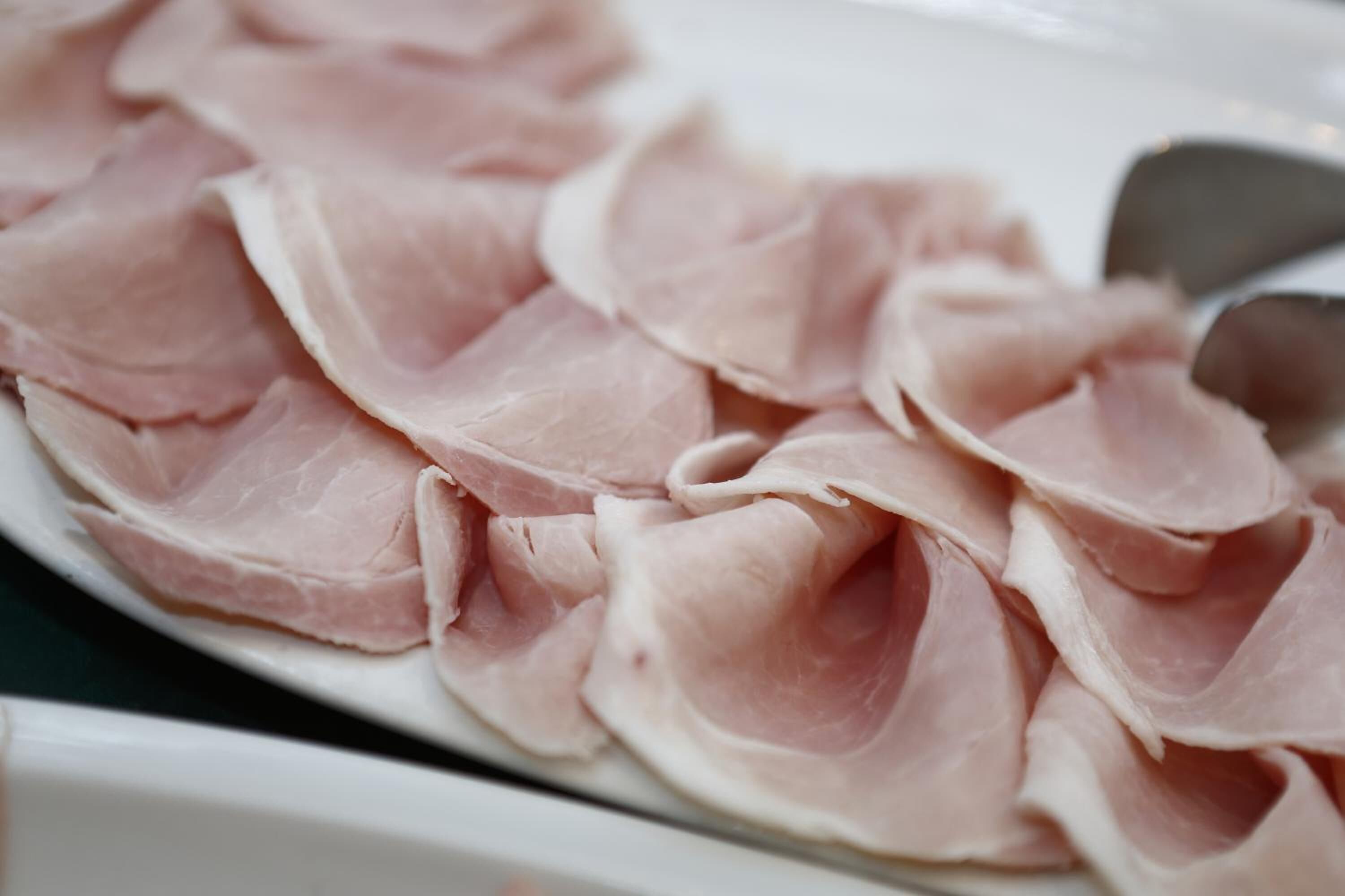 Une assiette de fines tranches de jambon disposées en cercle.