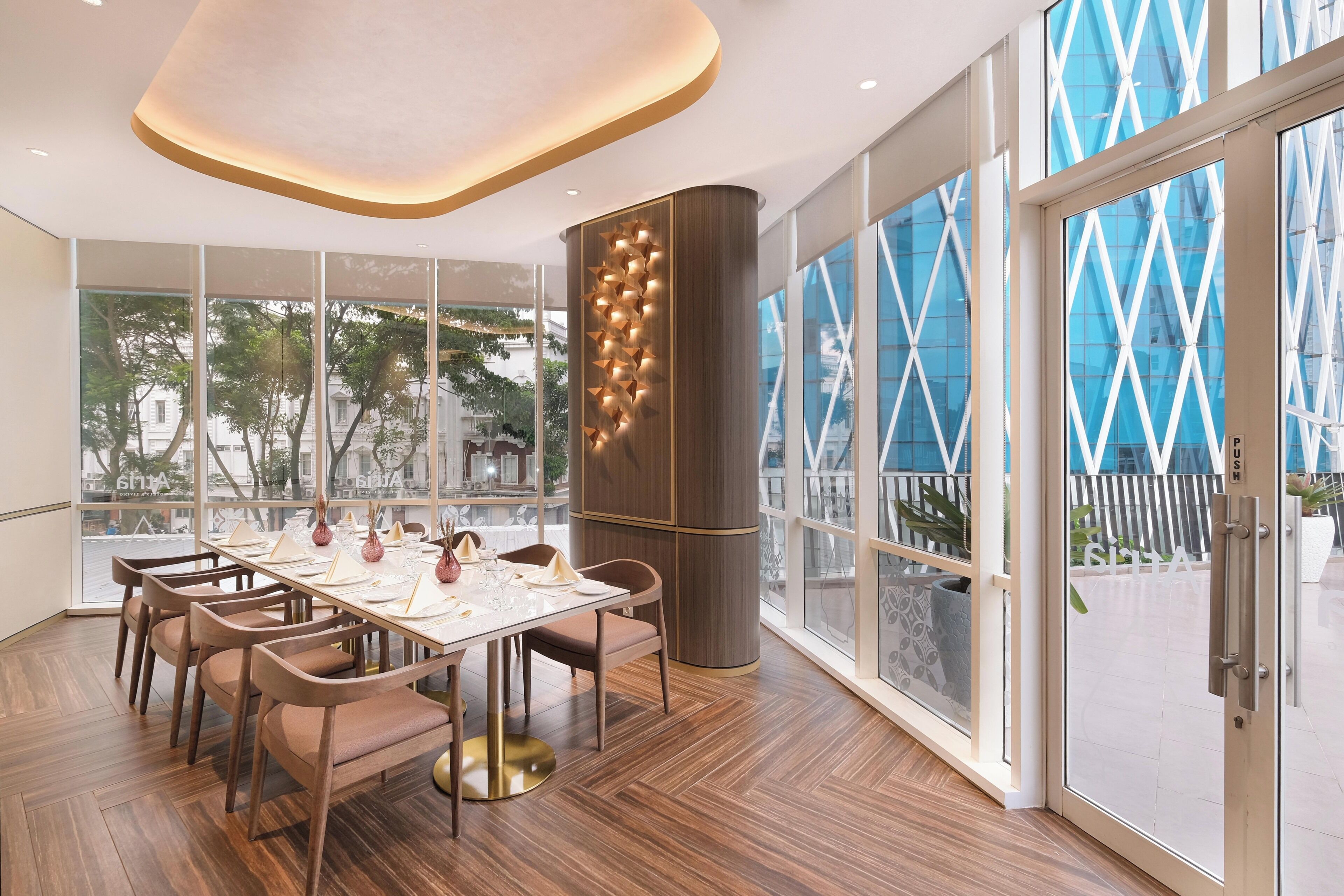 Un comedor moderno con una mesa grande, sillas y un muro decorativo.