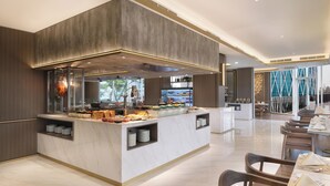 A modern hotel lobby with a marble reception desk, seating area, and large windows. - Atria Hotel Gading Serpong (Gading Serpong)