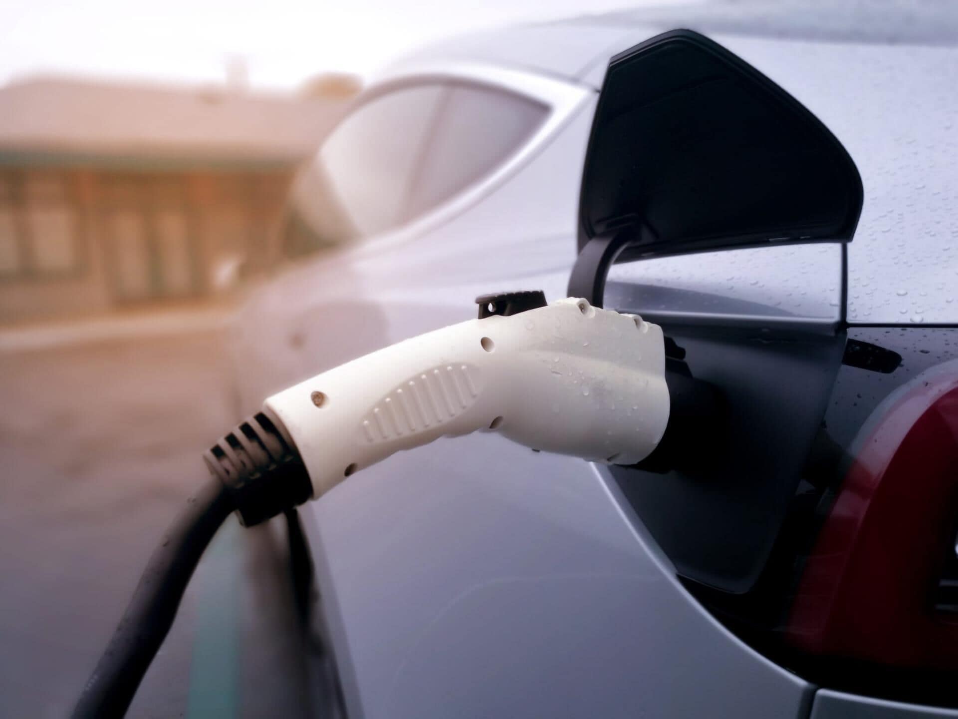Un câble de recharge pour voiture, branché sur la prise de recharge du véhicule.