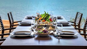 Mesa dispuesta para una comida con vista al mar.