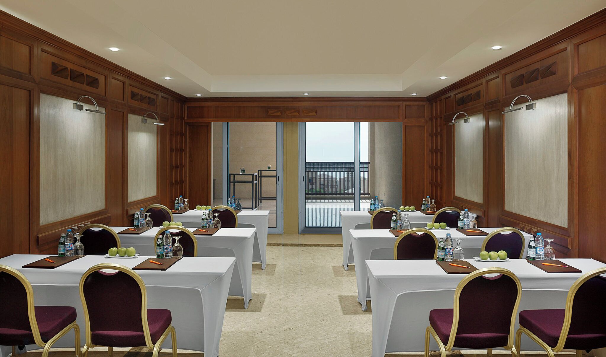A conference room with tables, chairs, and water bottles.