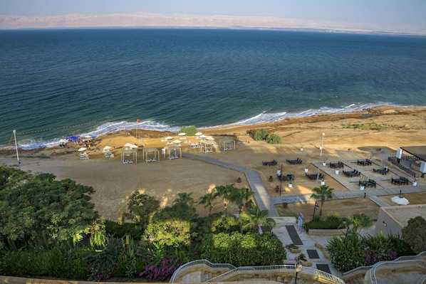 A beachside hotel with outdoor seating, a pool area, and a view of the ocean. - Crowne Plaza Jordan Dead Sea Resort & Spa by IHG (Sweimeh)