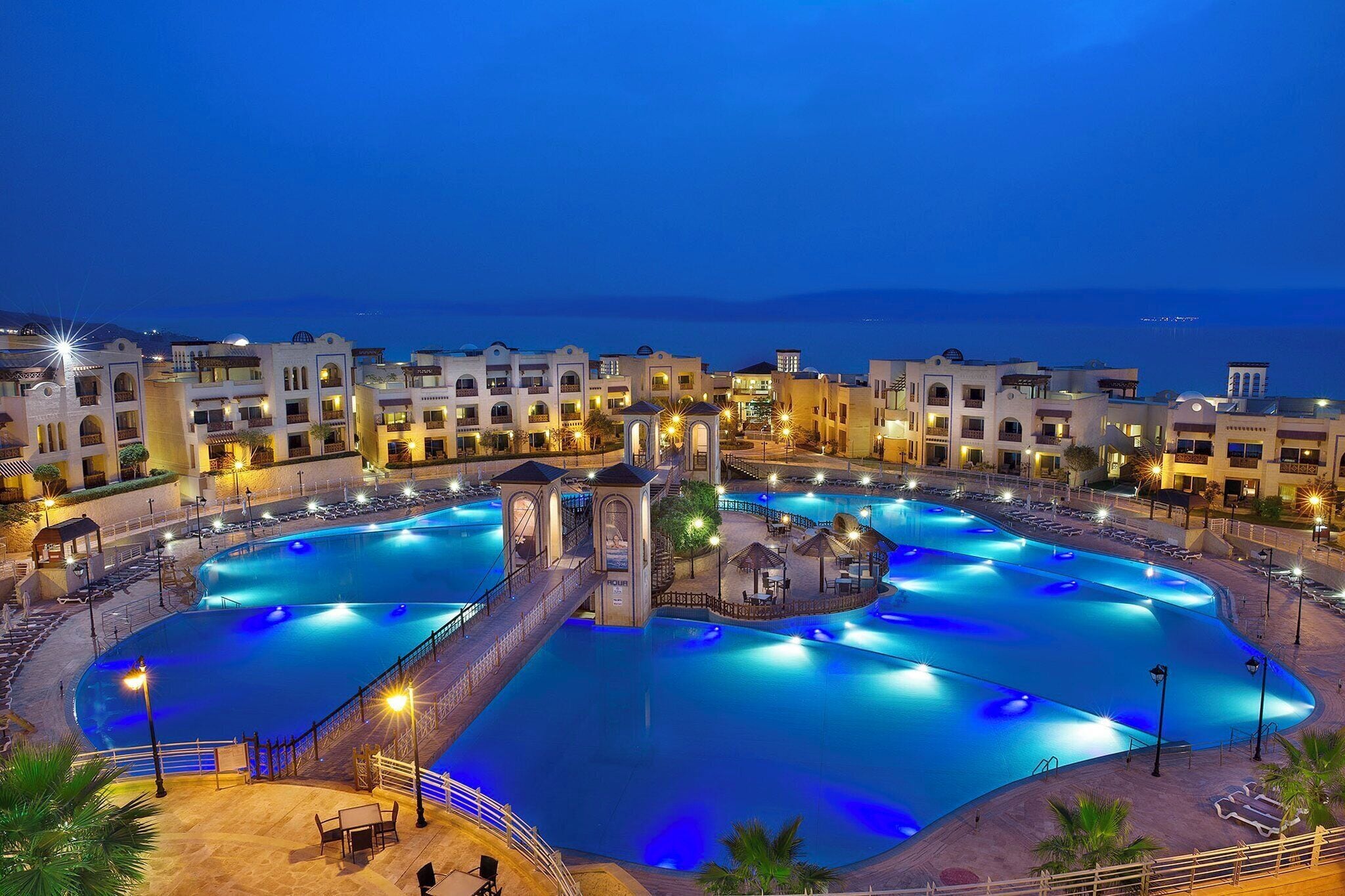 A large, multi-level swimming pool complex with multiple entry points and surrounding buildings.